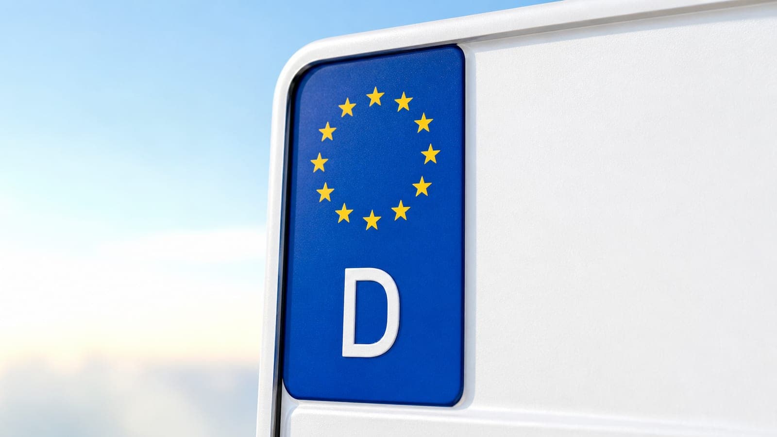 Deutsches Kfz-Kennzeichen mit blauer EU-Leiste vor freundlichem hellem Himmel